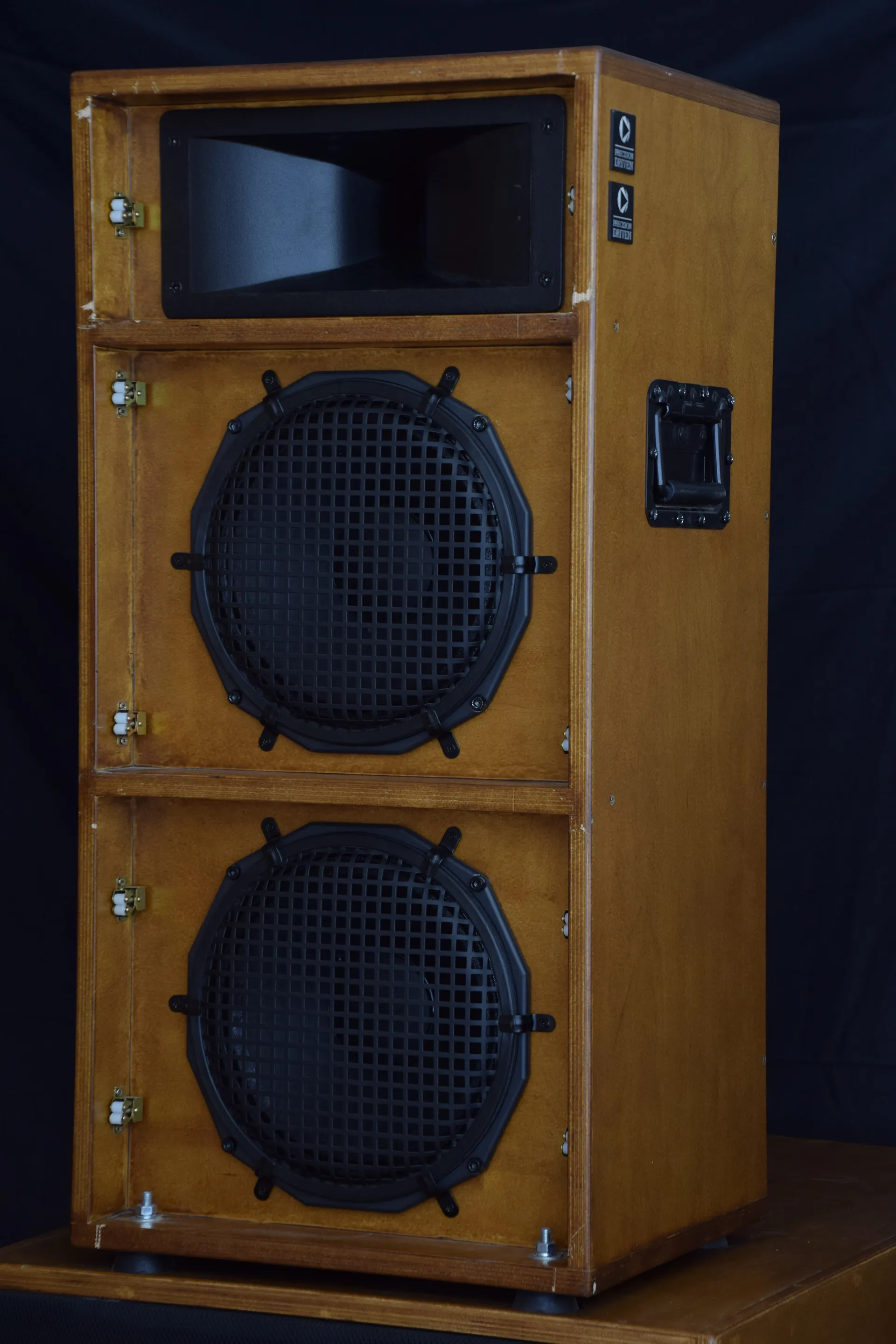 The same cabinet without its grille: a horn over two woofers