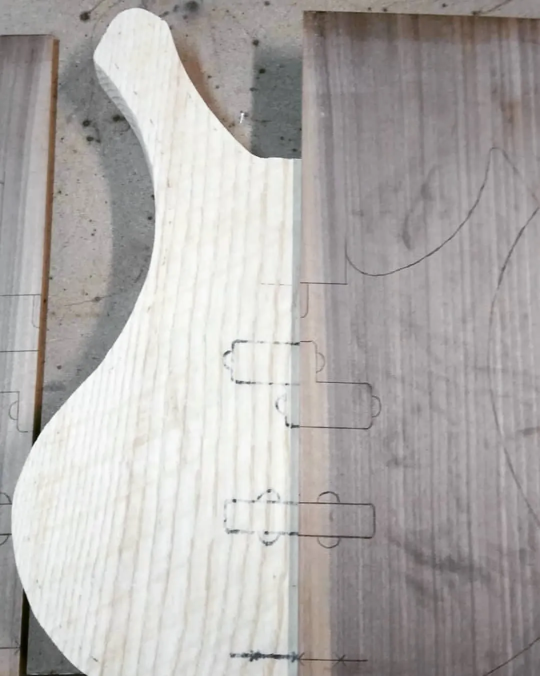 The cut ash body next to the walnut for its top